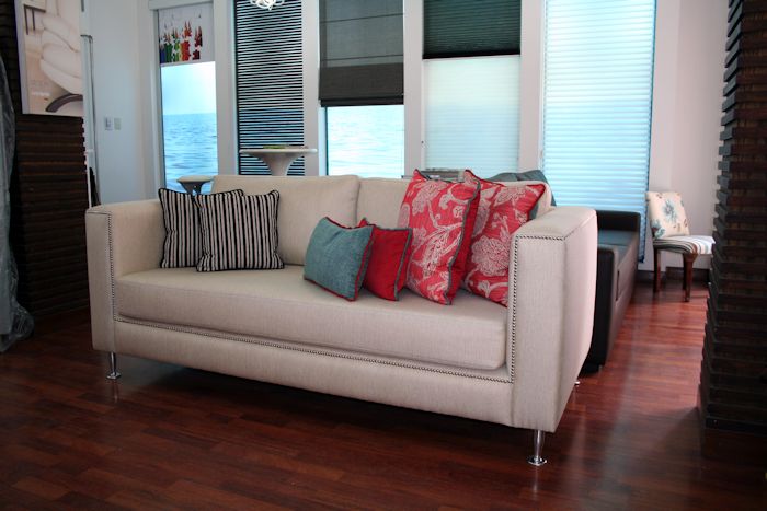 Sofá 2 cuerpos modelo cubo tela color crudo: brazo y respaldo recto mismo alto almohadón de asiento en placa entera cubierta de guata con lienzo interno, almohadón de respaldo en dos cuerpos relleno de duvetina o vellón con interior de lienzo, detalle de tachas plateadas o niqueladas (es lo mismo) en contorno, patas tonel aluminio.