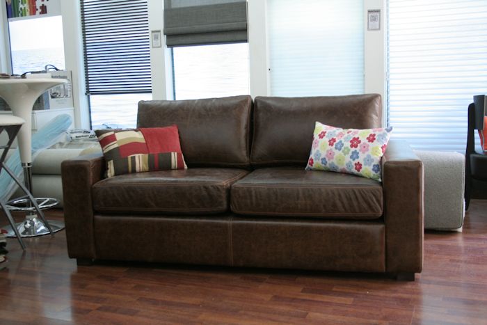 sofá en cuero de vaca:  brazo recto, asientos dividido en dos cuerpos relleno la placa sofá alta densidad cubierto con guata y lienzo interno, respaldo duvetina o vellón siliconados con funda de lienzo, detalle de doble costura aguante o francesa en todo el sofá, patas madera color Wengue.